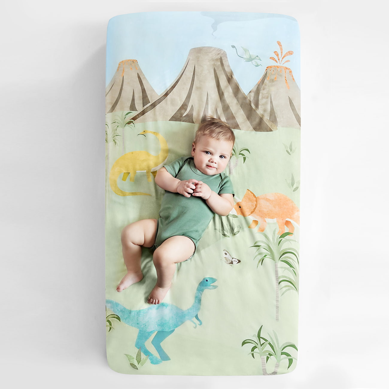 Dinosaur crib sheet with yellow orange and blue dinosaurs