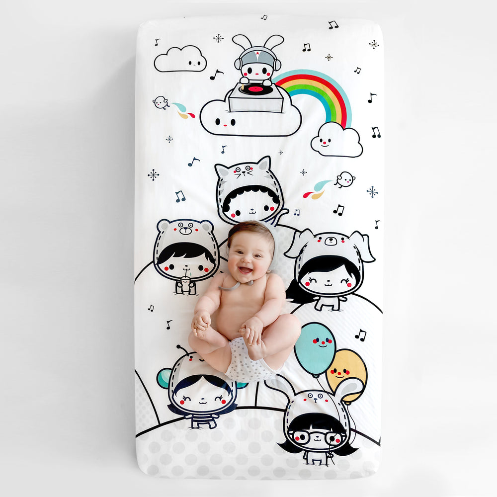 Fitted baby crib sheet by Rookie Humans, Party In My Crib, rainbow baby crib sheet. Illustrated by Elisa Sassi. Designed for the modern nursery, packaged to make a unique baby shower gift. Party DJ theme, balloons, music nursery theme, kawaii illustration.