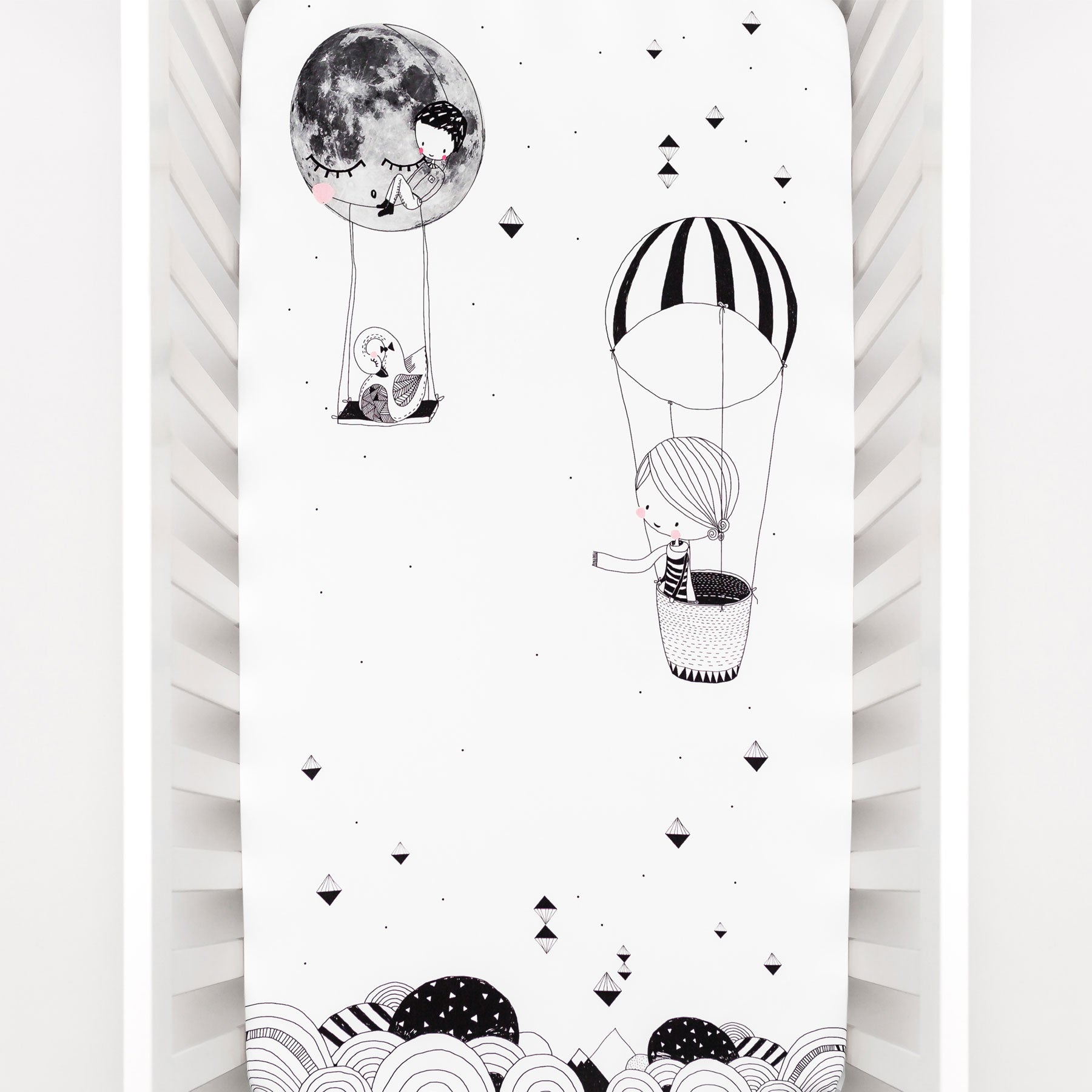 Fitted baby crib sheet by Rookie Humans, Frieda and the hot air balloon. Illustrated by Swanjte Hinrichsen. Designed for the modern nursery, packaged to make a unique baby shower gift. Monochrome nursery.