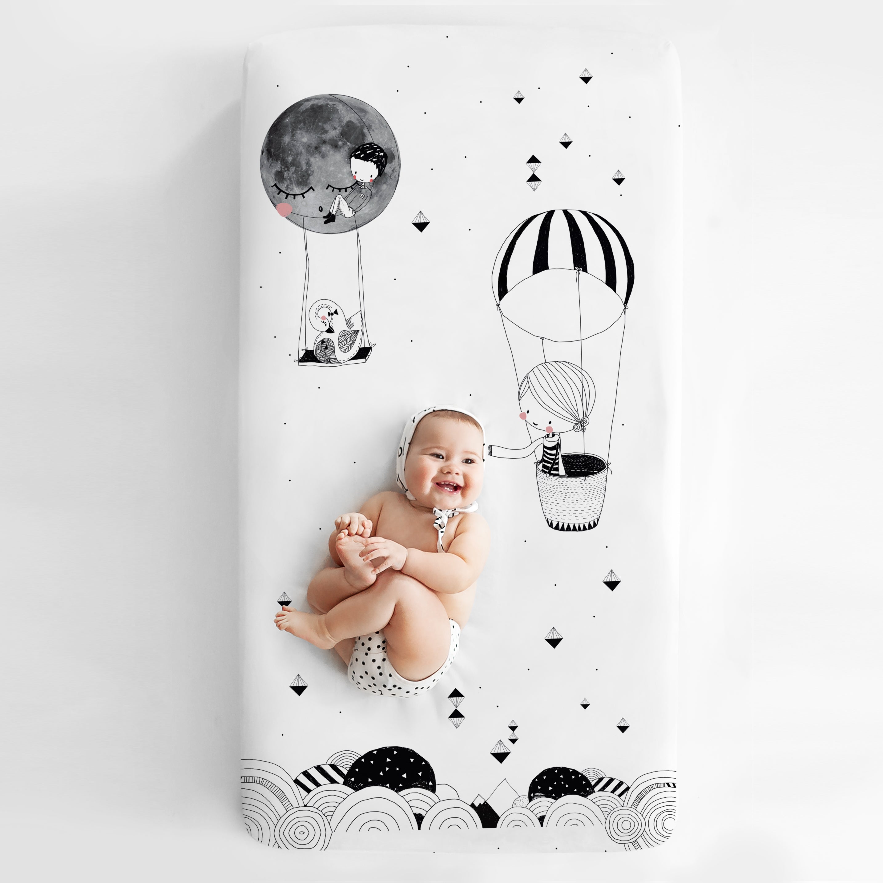 Fitted baby crib sheet by Rookie Humans, Frieda and the hot air balloon. Illustrated by Swanjte Hinrichsen. Designed for the modern nursery, packaged to make a unique baby shower gift. Monochrome nursery.