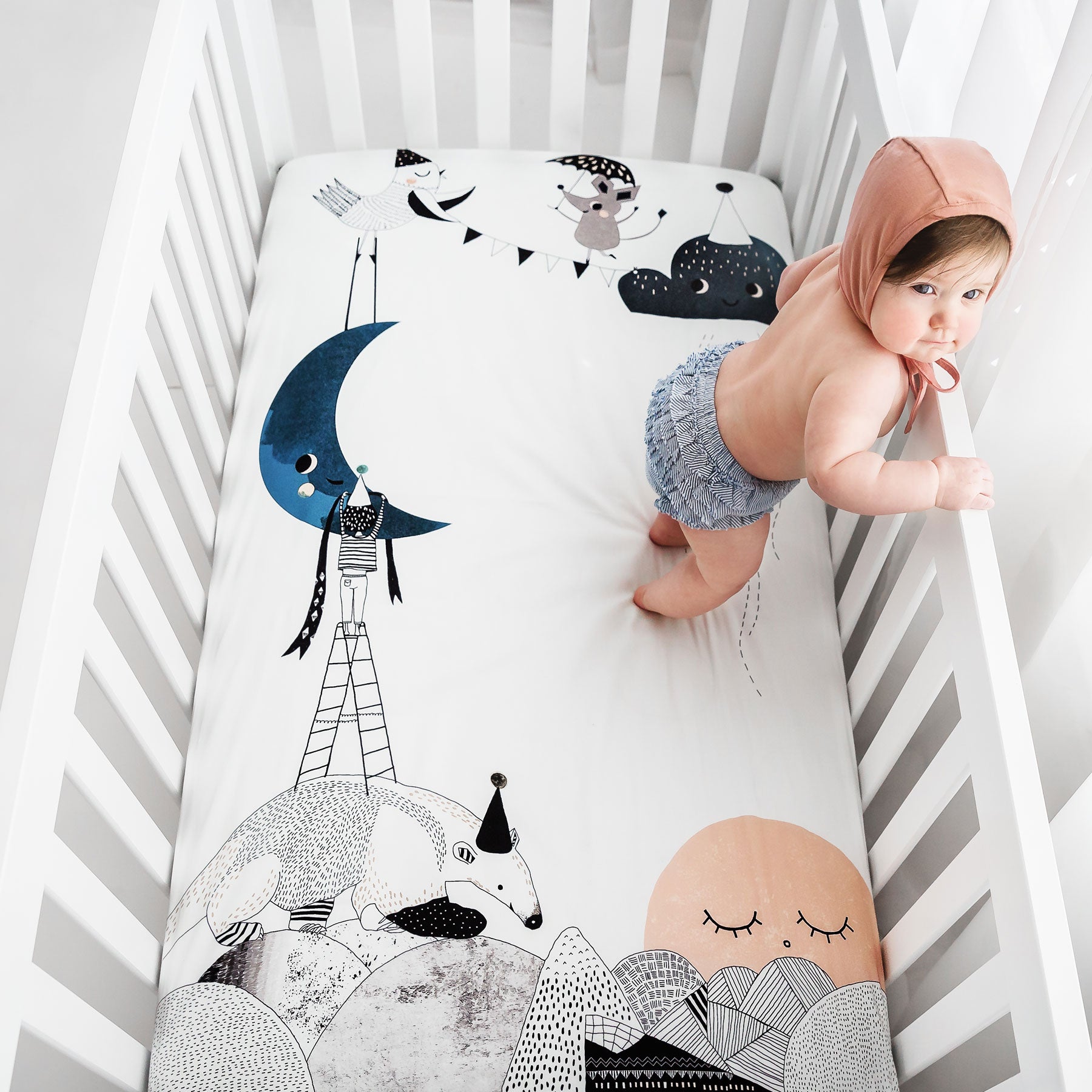 Fitted baby crib sheet by Rookie Humans, The Moon's Birthday. Illustrated by Swanjte Hinrichsen. Designed for the modern nursery, packages to make a unique baby shower gift.
